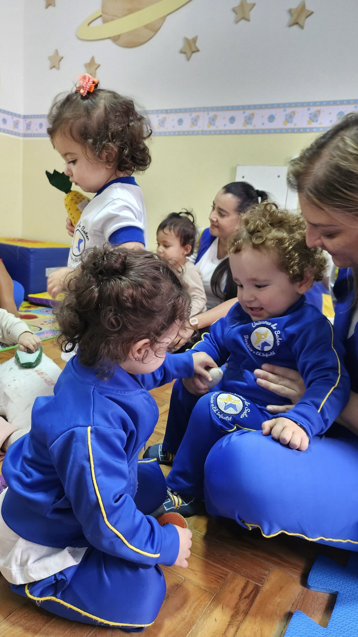 Bebês em atividade acompanhada por educadoras