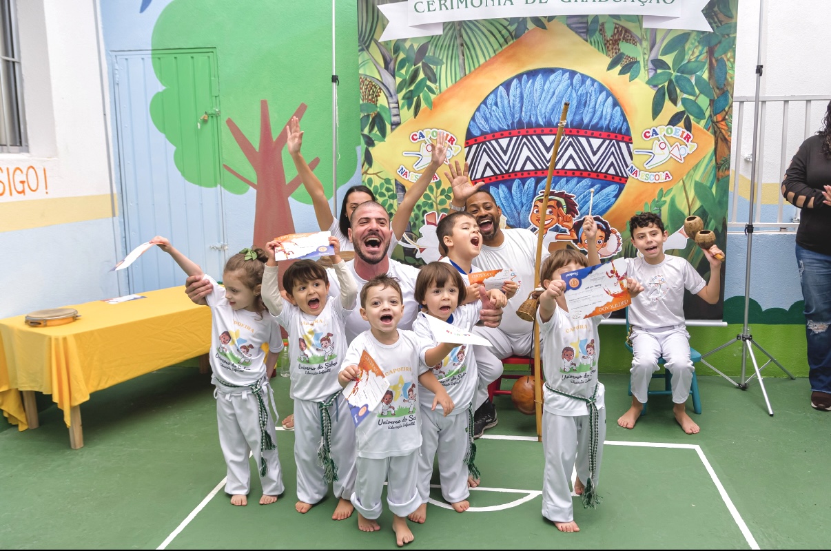 Crianças celebrando uma atividade de capoeira na escola
